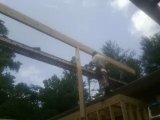 Carpenter setting a ridge beam over a new addition frame — Ice Dam Removal by Roofing Brothers in Southampton