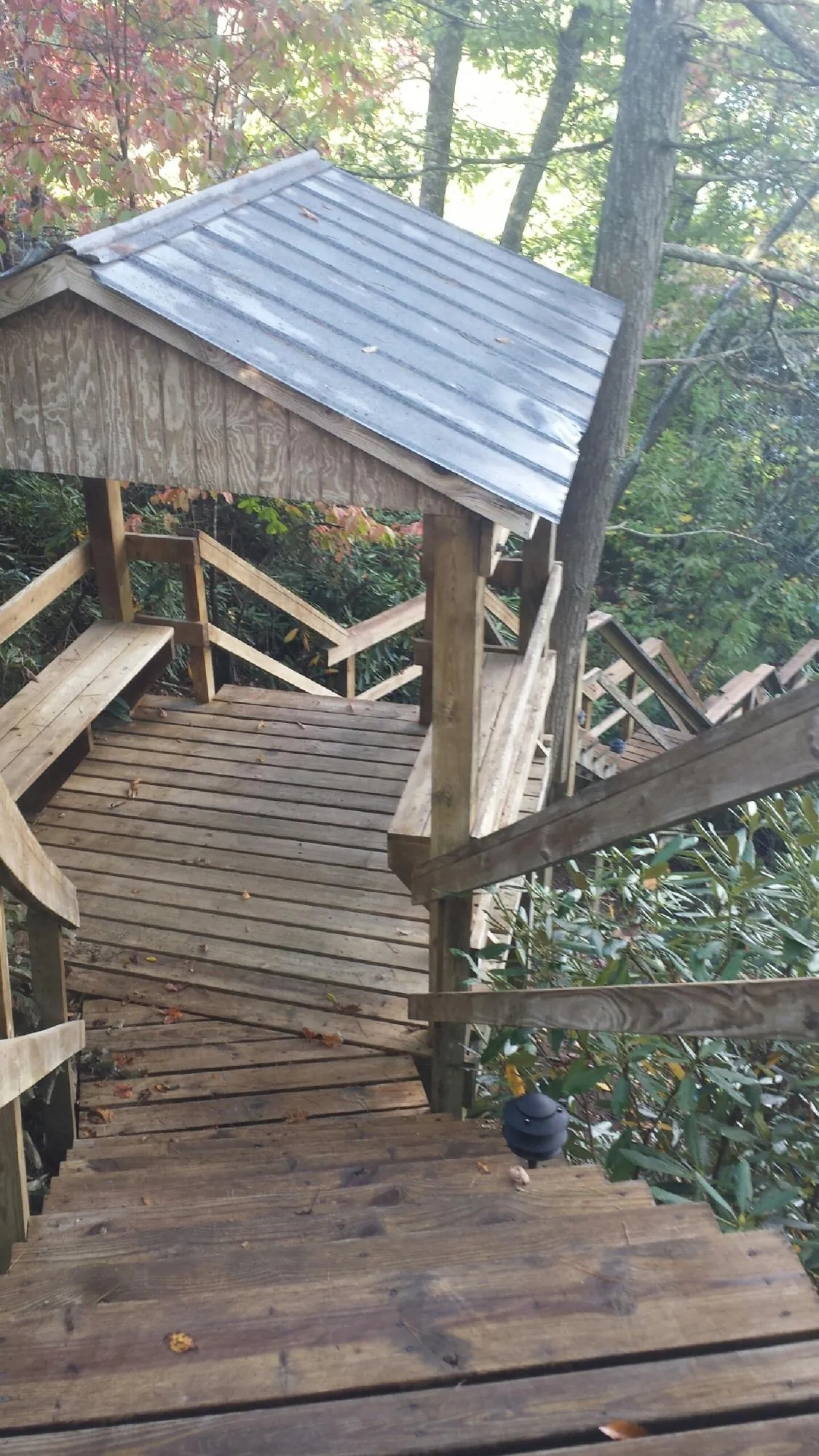 Metal roofed shelter over wooden steps on a wooded walkway — Skylight Repair & Installation work by our crew in Southampton